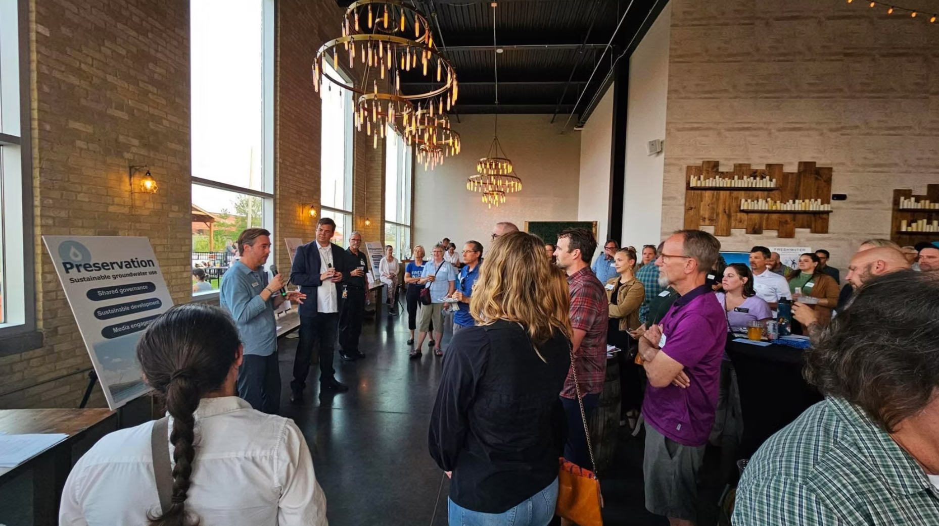 Guests gathered under chandeliers in the brick hall